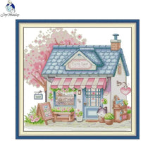 Load image into Gallery viewer, Cross-stitch pattern of a cute shop with a cherry blossom tree and blue border.