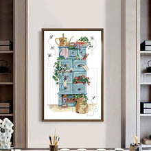 Load image into Gallery viewer, Framed artwork of a blue cabinet with decorative items on a white wall.