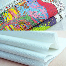 Load image into Gallery viewer, Rolls of colorful fabric and white mesh fabric on a light surface.
