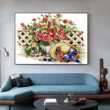 Load image into Gallery viewer, Decorative painting of flowers and a basket on a wall above a blue sofa.