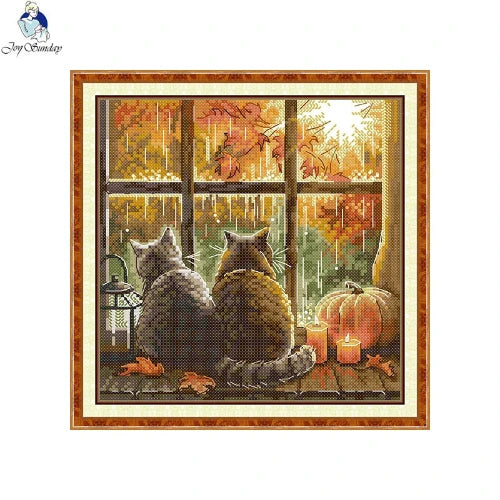 Two cats looking out a window with Halloween decorations, including pumpkins and a full moon.