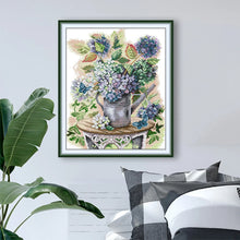 Load image into Gallery viewer, Framed floral artwork on a wall with decorative pillows and a plant.
