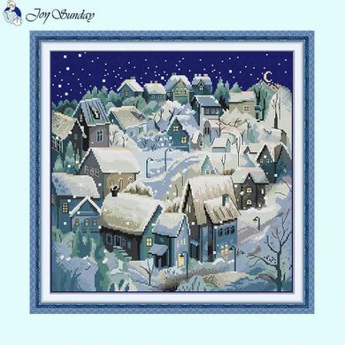 Glowing snowy night cross stitch showing cabin and northern lights effect